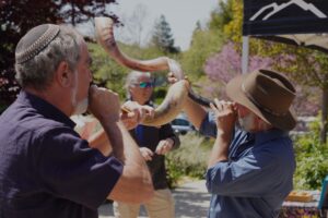 Rabbi Dan and Rabbi Zelig blowing the Shofar in the courtyard at the 2023 EarthFest.